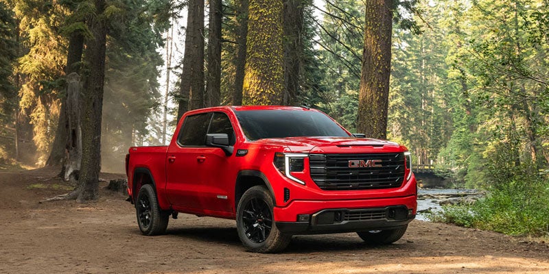 2026 GMC Sierra 1500 red pickup truck in forest setting