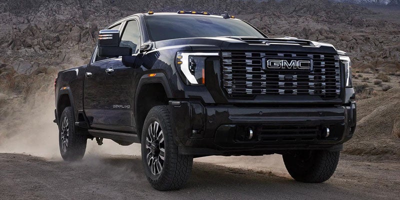 2026 GMC Sierra 2500 HD black truck on rocky terrain