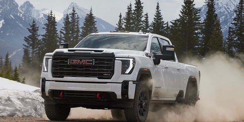 2026 GMC Sierra 2500 HD white truck in snowy mountains